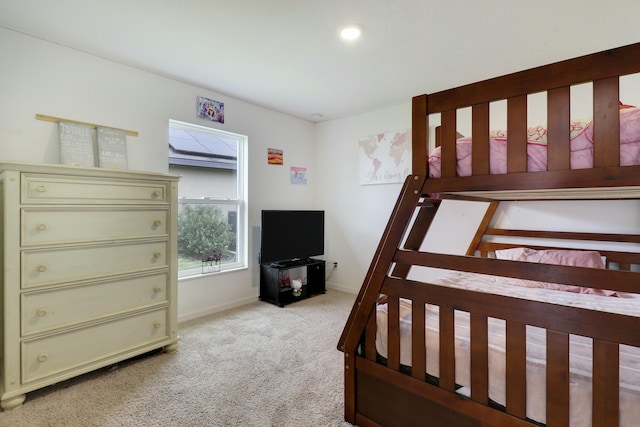 bedroom with baseboards and light colored carpet