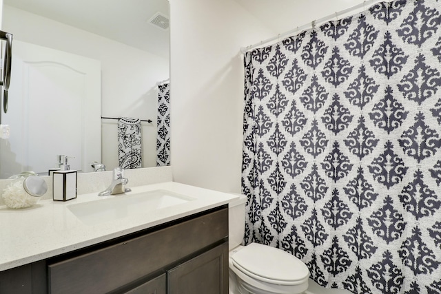 bathroom featuring toilet, visible vents, and vanity