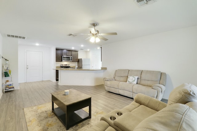 living area featuring a ceiling fan, visible vents, and light wood-style flooring