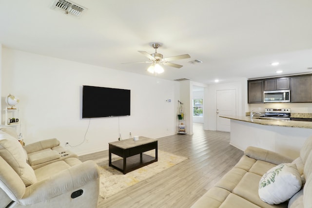 living room featuring a ceiling fan, recessed lighting, visible vents, and light wood-style floors