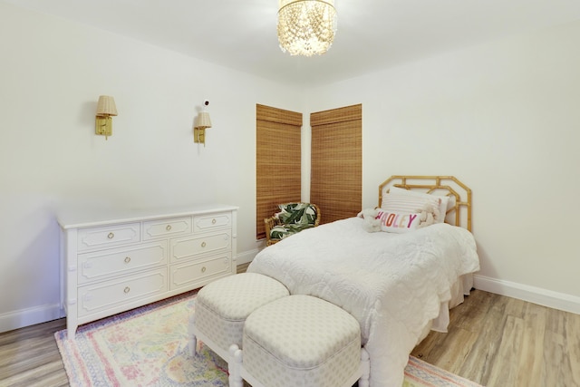 bedroom featuring a notable chandelier and light wood-type flooring