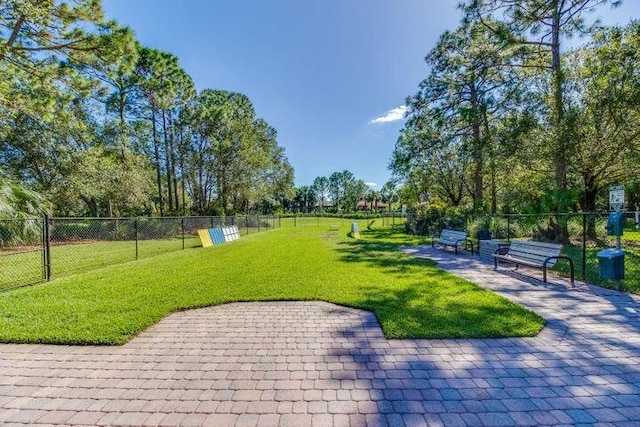 view of property's community with a patio area and a lawn