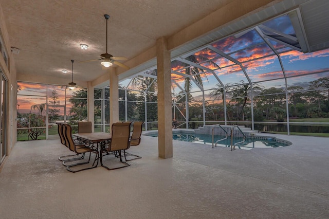 patio terrace at dusk featuring glass enclosure