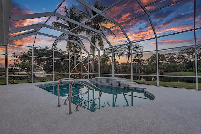 pool at dusk with a water view, a lanai, and a patio