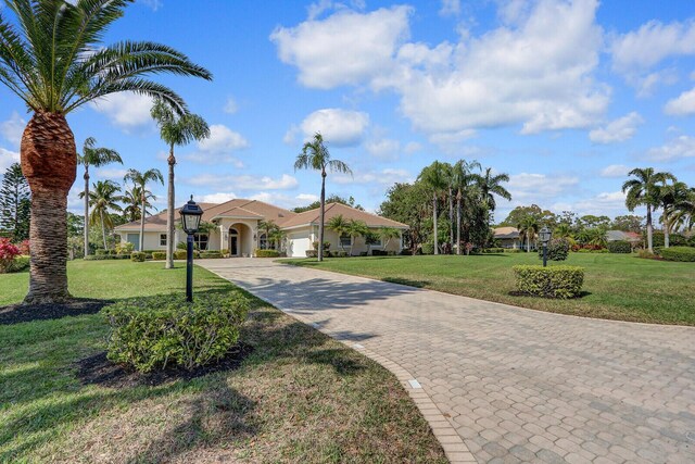 single story home with a garage and a front lawn