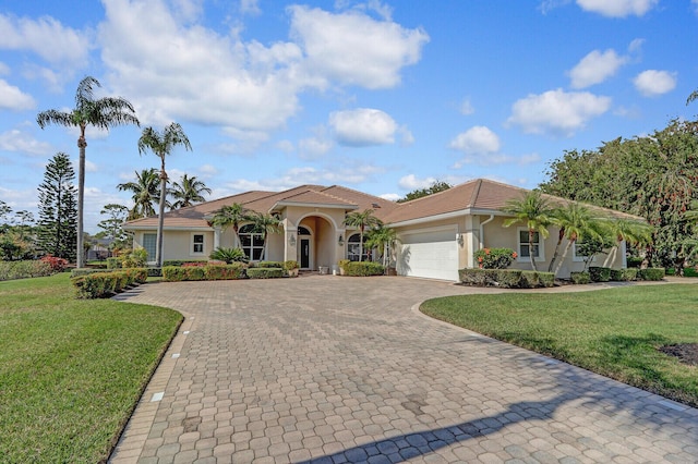 mediterranean / spanish house featuring a garage and a front yard