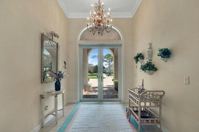 tiled foyer featuring ornamental molding, an inviting chandelier, and french doors