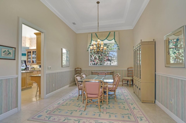 tiled dining area featuring crown molding, an inviting chandelier, and a tray ceiling