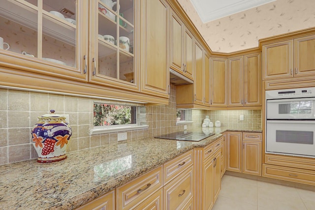 kitchen featuring crown molding, white double oven, light stone counters, light tile patterned flooring, and black electric cooktop