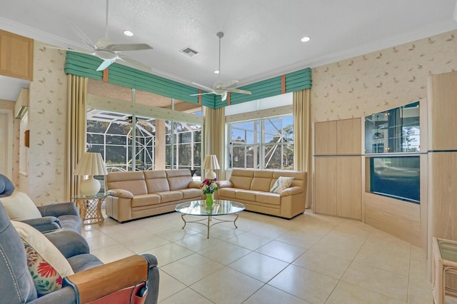 living room featuring ornamental molding, light tile patterned floors, a textured ceiling, and ceiling fan