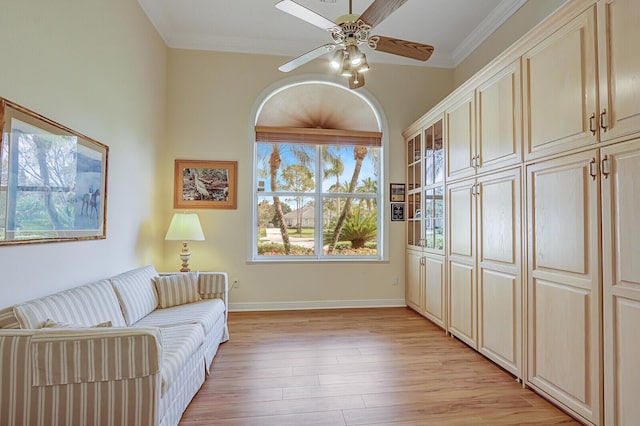 living area featuring crown molding, light hardwood / wood-style flooring, and ceiling fan