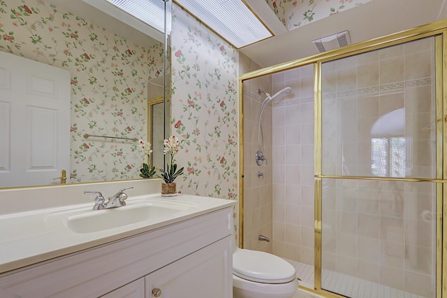 bathroom with walk in shower, vanity, and toilet