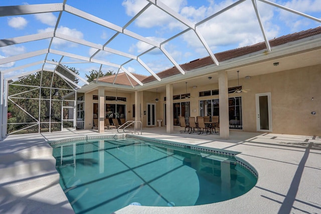 view of pool featuring a patio, ceiling fan, and glass enclosure