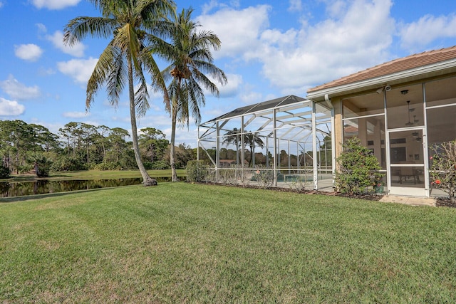 view of yard featuring a water view and glass enclosure