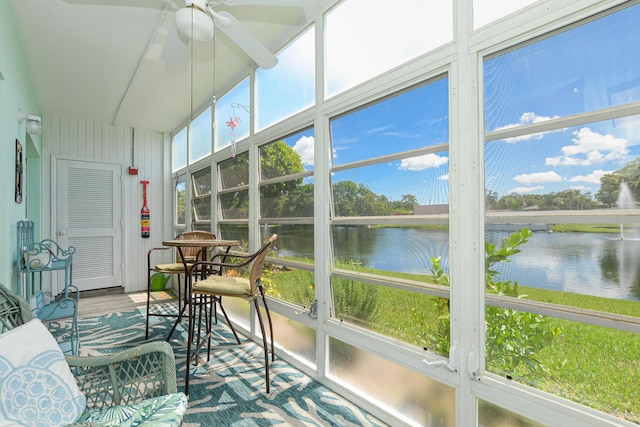 sunroom with a water view and ceiling fan