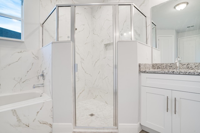 bathroom featuring vanity and independent shower and bath