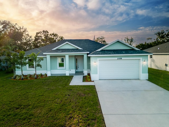 ranch-style house with a yard and a garage