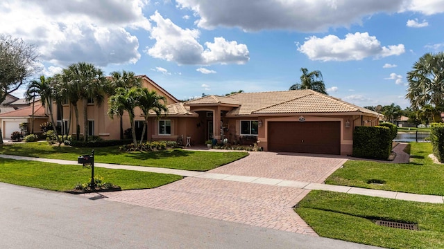 mediterranean / spanish home with a garage and a front lawn