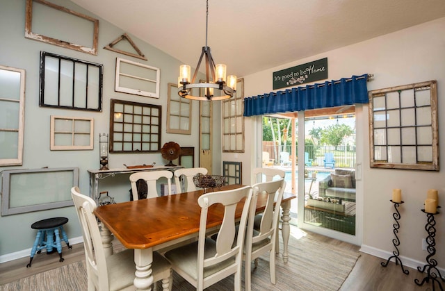 dining area featuring an inviting chandelier, hardwood / wood-style floors, and vaulted ceiling