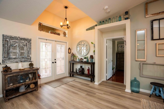 entrance foyer featuring french doors, an inviting chandelier, and hardwood / wood-style floors