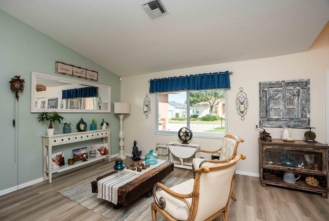 sitting room featuring hardwood / wood-style flooring and vaulted ceiling