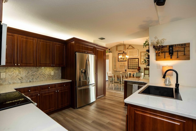 kitchen featuring pendant lighting, sink, stainless steel refrigerator with ice dispenser, tasteful backsplash, and dark hardwood / wood-style flooring