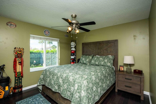 bedroom with ceiling fan, dark hardwood / wood-style floors, and a textured ceiling