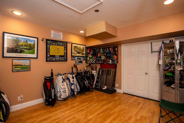 misc room with light hardwood / wood-style floors and a textured ceiling