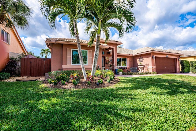 mediterranean / spanish-style home with a garage and a front lawn