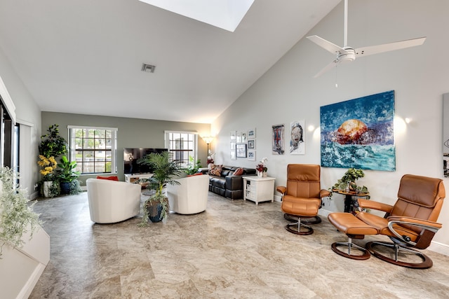 living room featuring a skylight and high vaulted ceiling