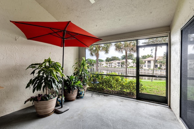 unfurnished sunroom featuring plenty of natural light and a water view