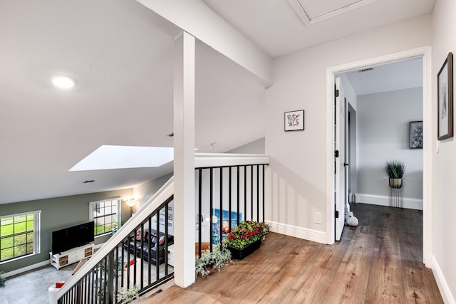 hallway featuring hardwood / wood-style floors and a skylight