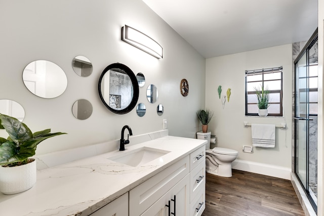 bathroom with vanity, hardwood / wood-style flooring, toilet, and walk in shower