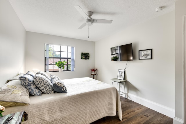 bedroom featuring ceiling fan, dark hardwood / wood-style floors, and a textured ceiling