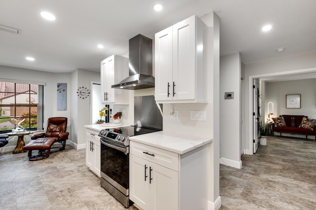 kitchen featuring white cabinetry, wall chimney exhaust hood, and electric range