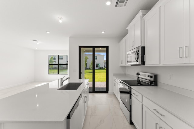 kitchen with visible vents, an island with sink, appliances with stainless steel finishes, marble finish floor, and a sink