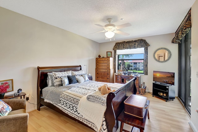 bedroom featuring ceiling fan, a textured ceiling, and light wood-type flooring