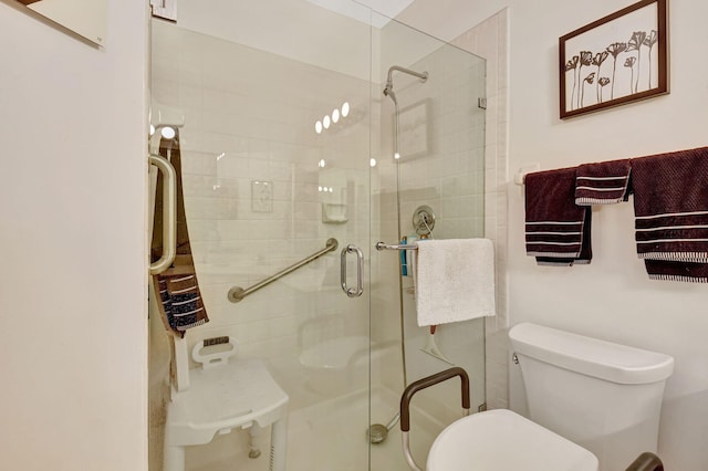 bathroom with a shower with shower door and toilet