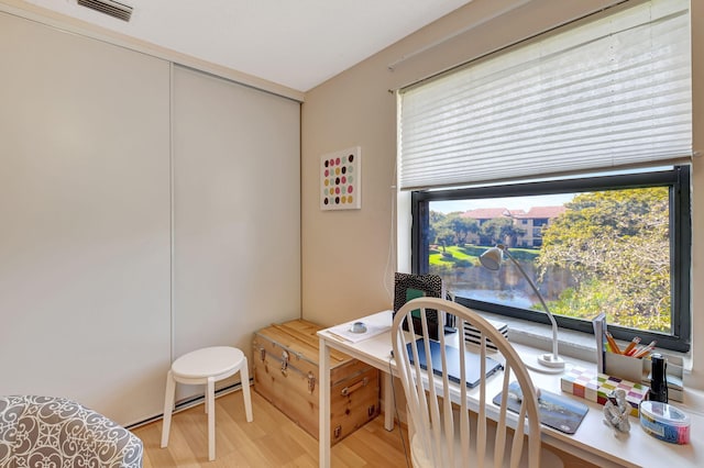 home office with plenty of natural light and light hardwood / wood-style floors