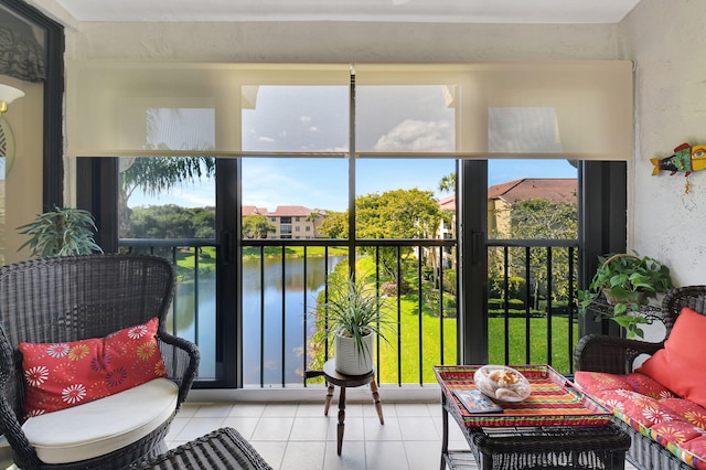 sunroom featuring a water view