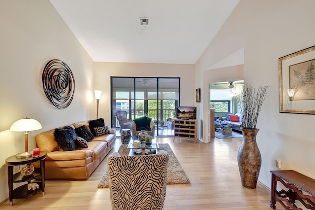 living room with high vaulted ceiling and light hardwood / wood-style floors