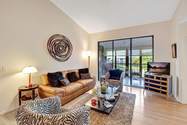 living room with light hardwood / wood-style floors and vaulted ceiling