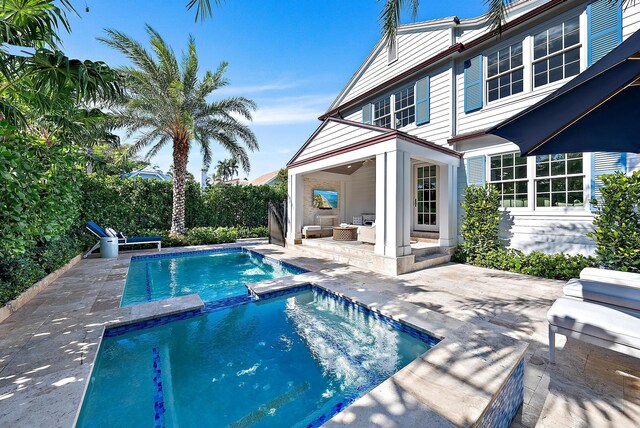 back of house with a pool with connected hot tub, an outdoor hangout area, and a patio