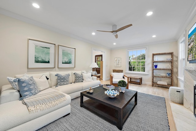 living room with light wood-type flooring, a fireplace, crown molding, and recessed lighting