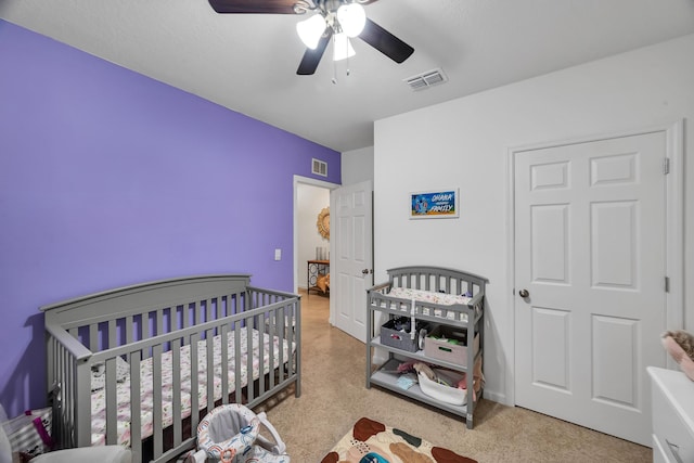 bedroom with a crib and ceiling fan