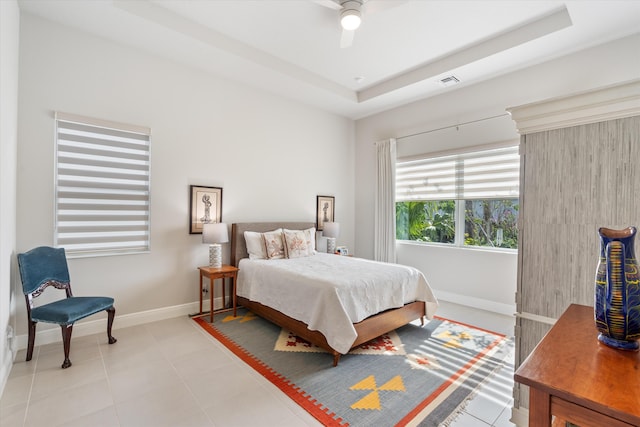 tiled bedroom featuring ceiling fan and a raised ceiling