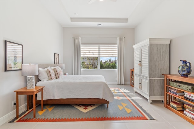 bedroom featuring a raised ceiling and light tile patterned flooring