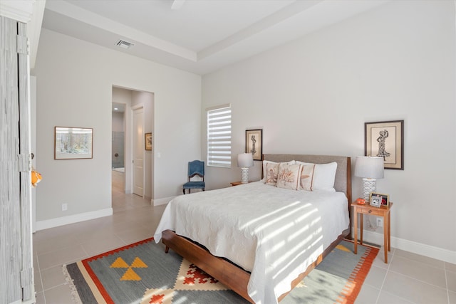 bedroom featuring a tray ceiling and light tile patterned floors