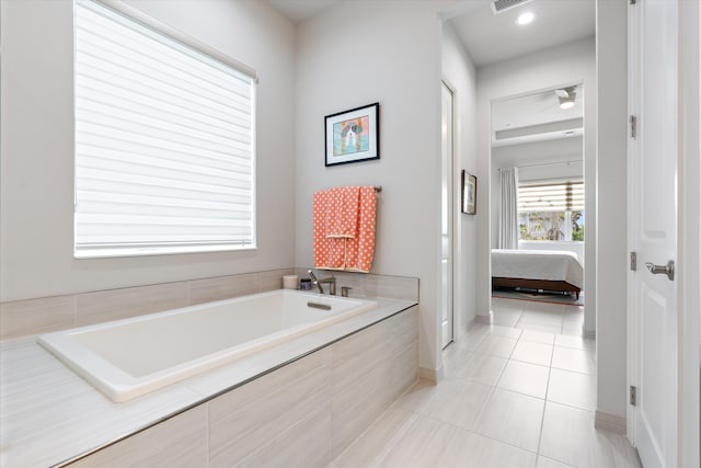 bathroom featuring tile patterned flooring and tiled bath