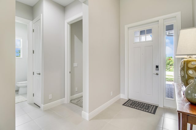 entryway with light tile patterned floors and baseboards